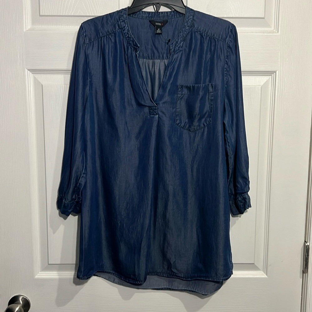 Intro. Women’s denim/Chambrey blouse with a V-neck & front pocket. Size Medium